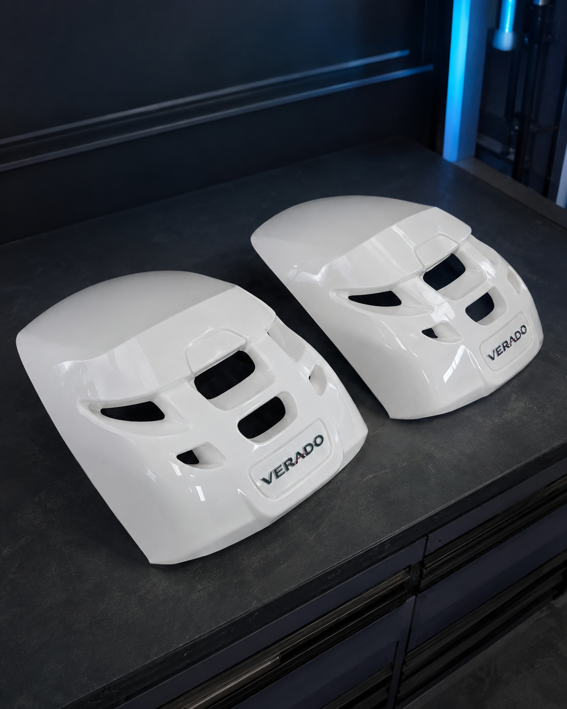 Two restored white Verado outboard engine cowlings with a high-gloss finish